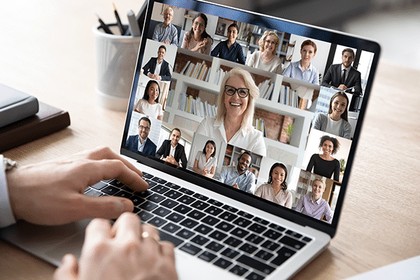 online-time-management-workshop A person participating in a video conference call on a laptop with multiple colleagues visible on the screen.